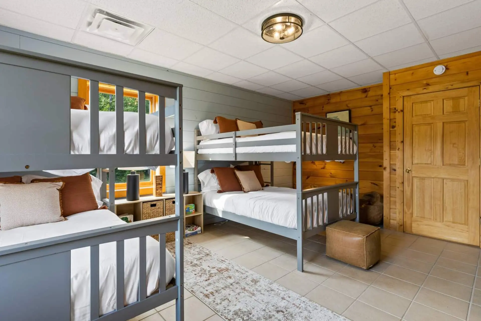 Perfect for kids or groups, this fun bunk room features four full-size beds, cozy reading spots, and a selection of games. A bright window adds natural light, creating a comfortable hangout space for relaxing, playing, or movie nights.