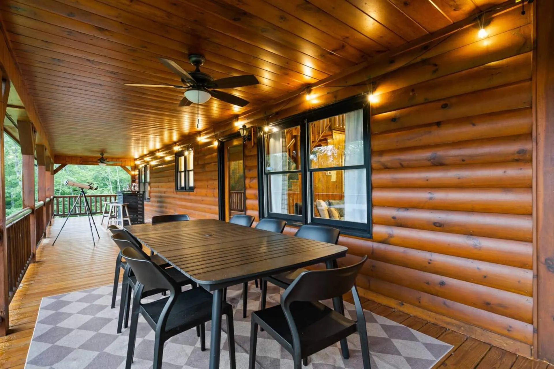 Gather together for meals on the spacious covered porch, featuring a large outdoor dining table with peaceful wooded views. It’s the perfect setting for breakfast, family dinners, or late-night conversations in the fresh mountain air.