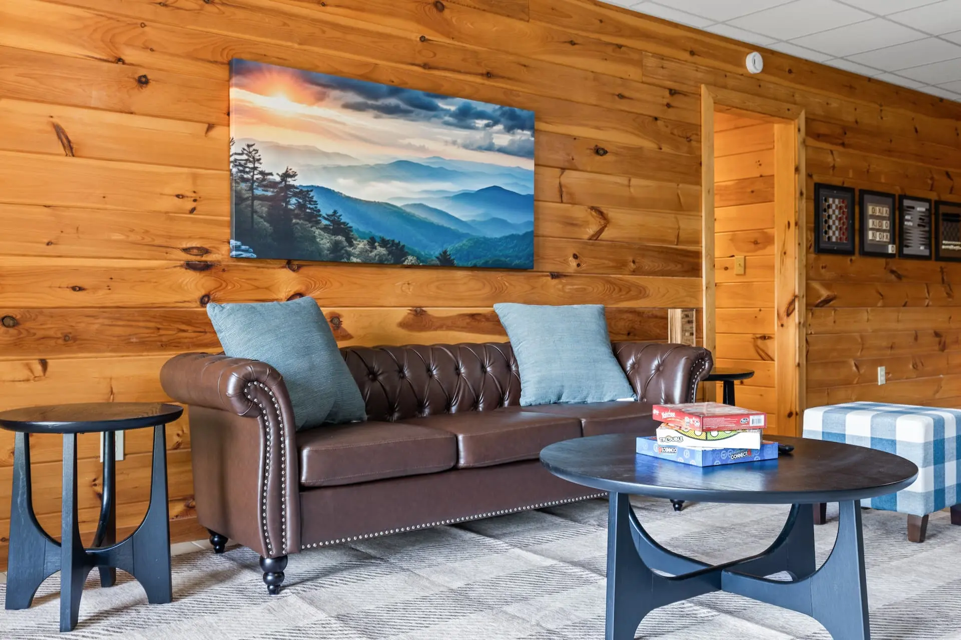 Relax between games in this cozy lounge area, featuring a stylish leather sofa, mountain-inspired décor, and a selection of board games. The perfect spot to unwind, chat, or plan your next round of fun.