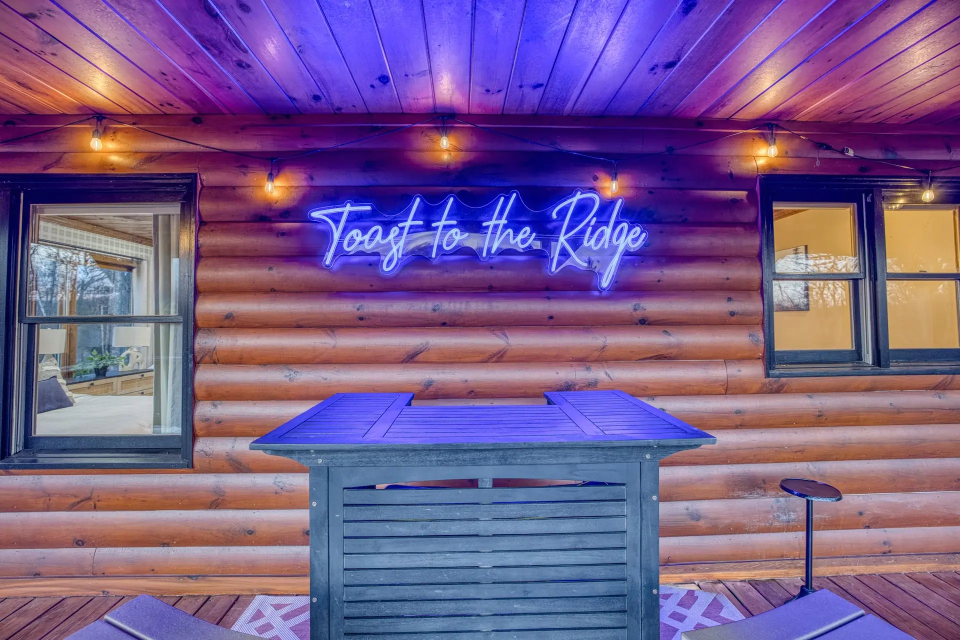 Neon-lit cabin porch bar with string lights—perfect for sunset sips while soaking in your mountain view!