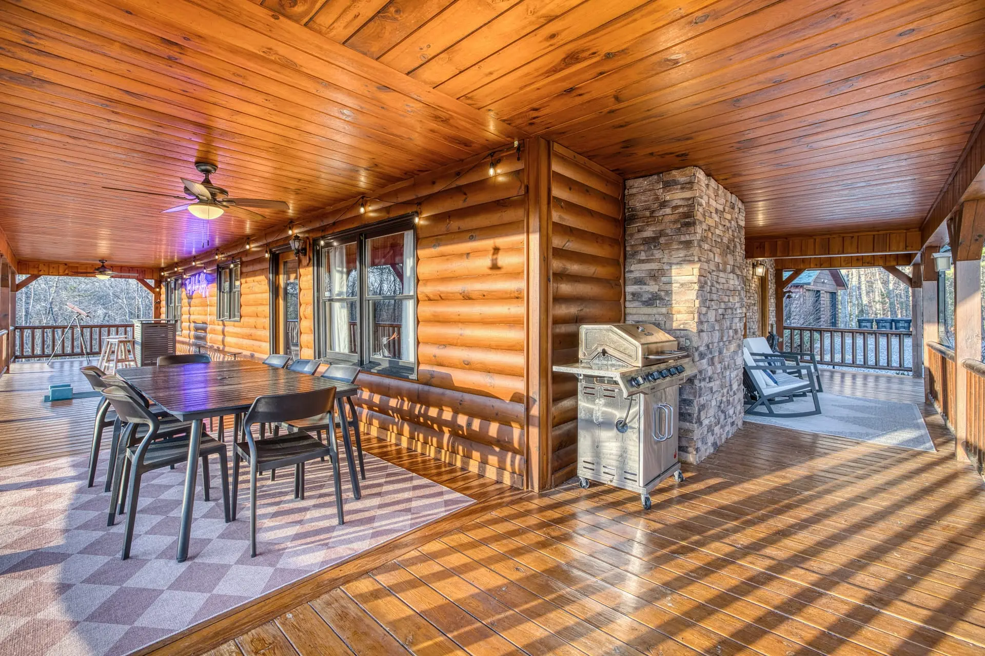 Spacious covered log deck with dining, grill & serene views