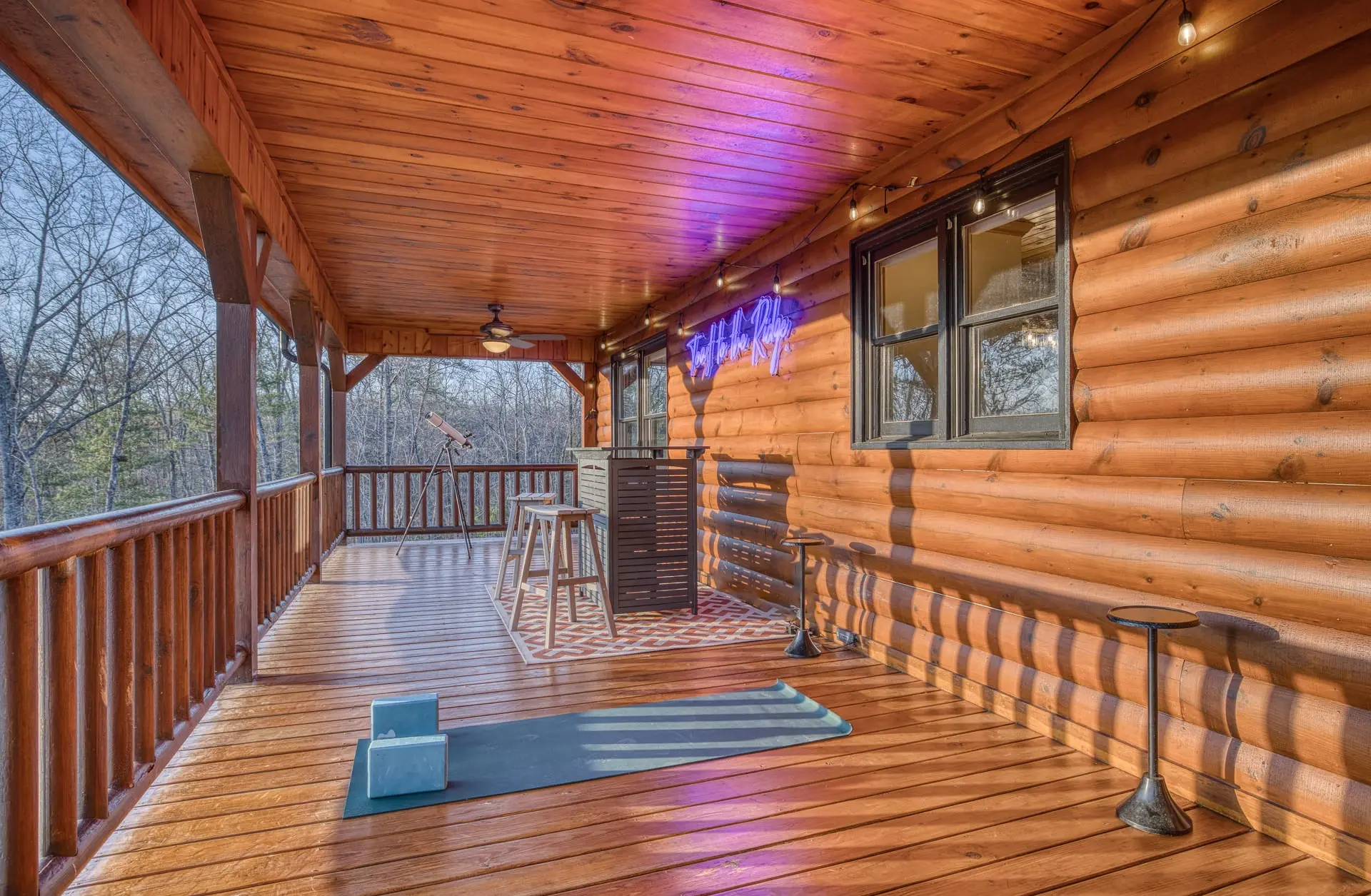 Spacious covered log deck with bar, yoga zone, and serene forest views.