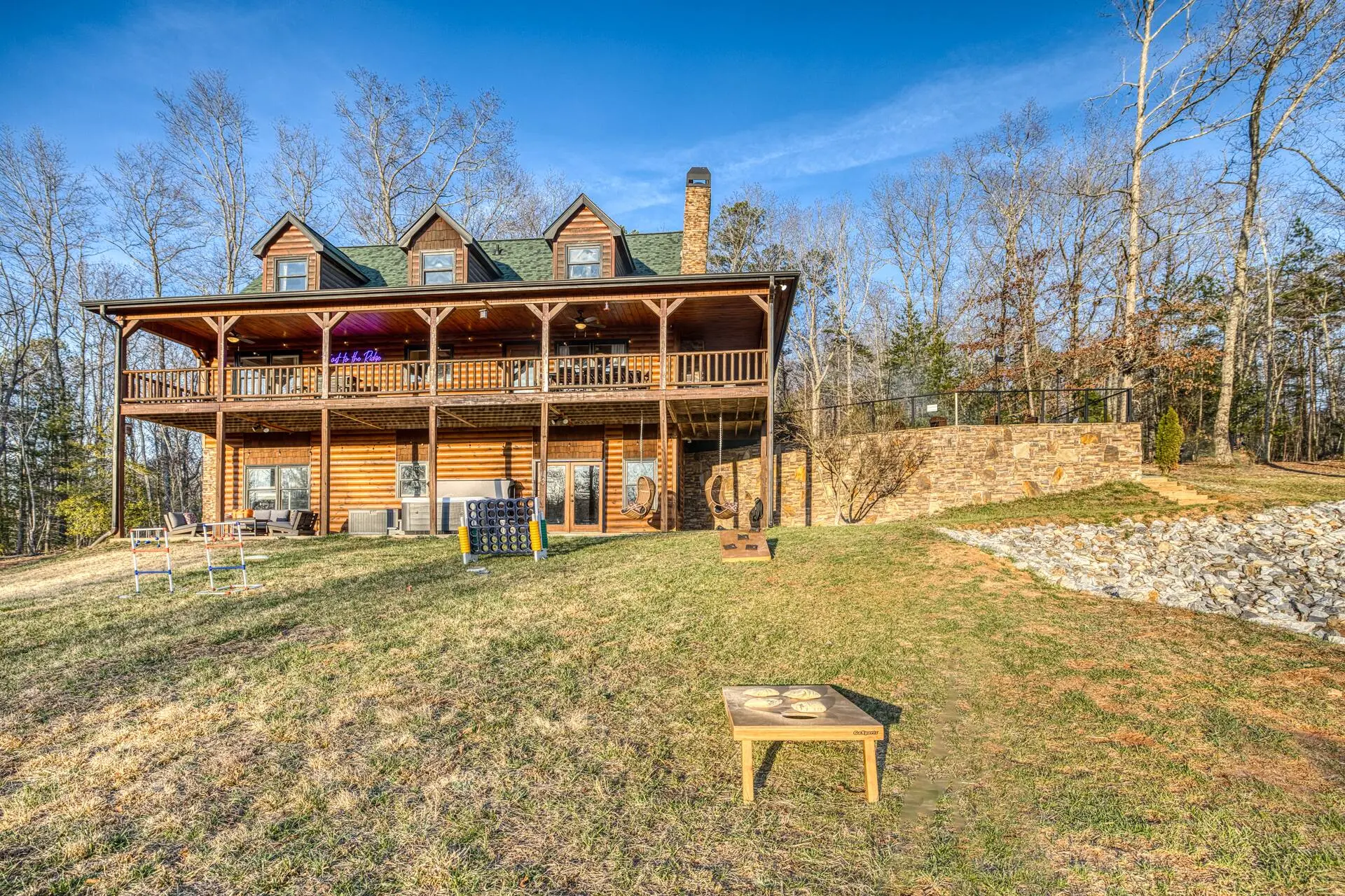 Rustic log lodge with wraparound porches, yard games & tranquil forest views